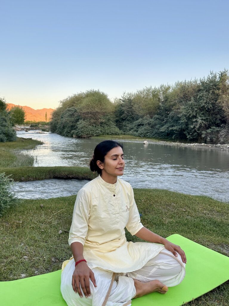 Rubika meditating by the tributary of Indus river adjoining the resort at the yoga retreat in Ladakh